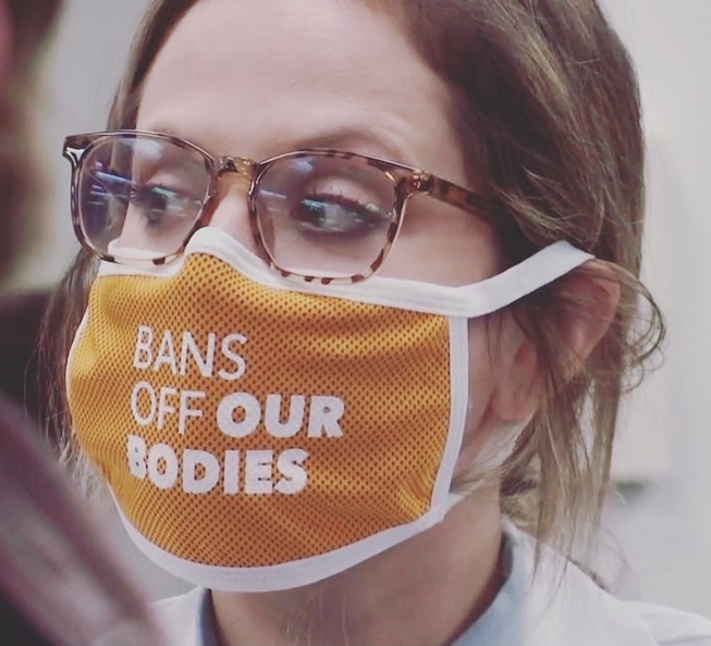 Hanna Peterson in a mask reading