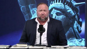 Alex Jones is seen sitting at a desk looking how he looks.