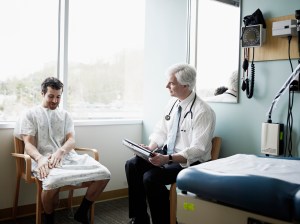 Male doctor in discussion with patient in exam room