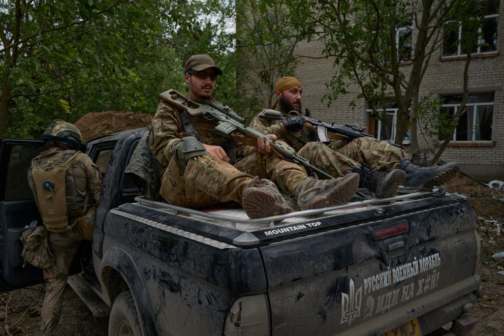 Ukrainian soldiers and foreign fighters board a vehicle on the frontline on June 27, 2022 in Mykolaiv, Ukraine