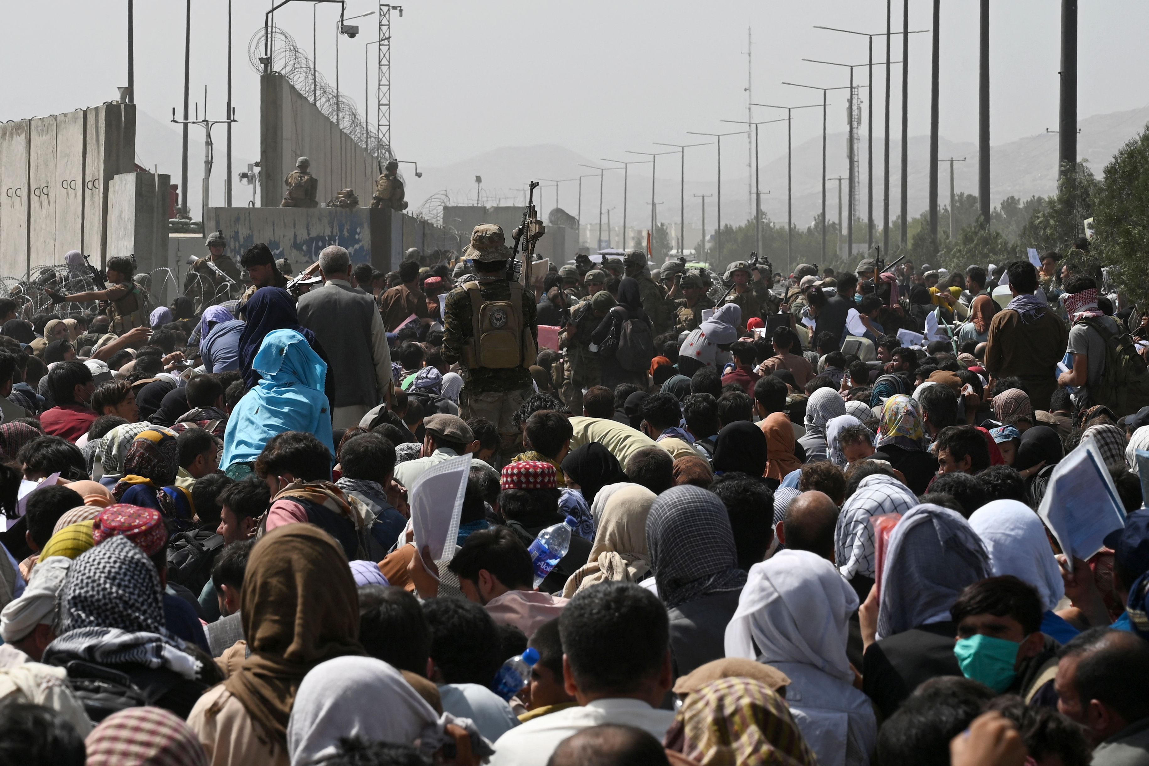 Afghans gather on a roadside near the military part of the airport in Kabul on August 20, 2021, hoping to flee from the country after the Taliban's military takeover of Afghanistan. Photo: Wakil Kohsar/AFP via Getty Images