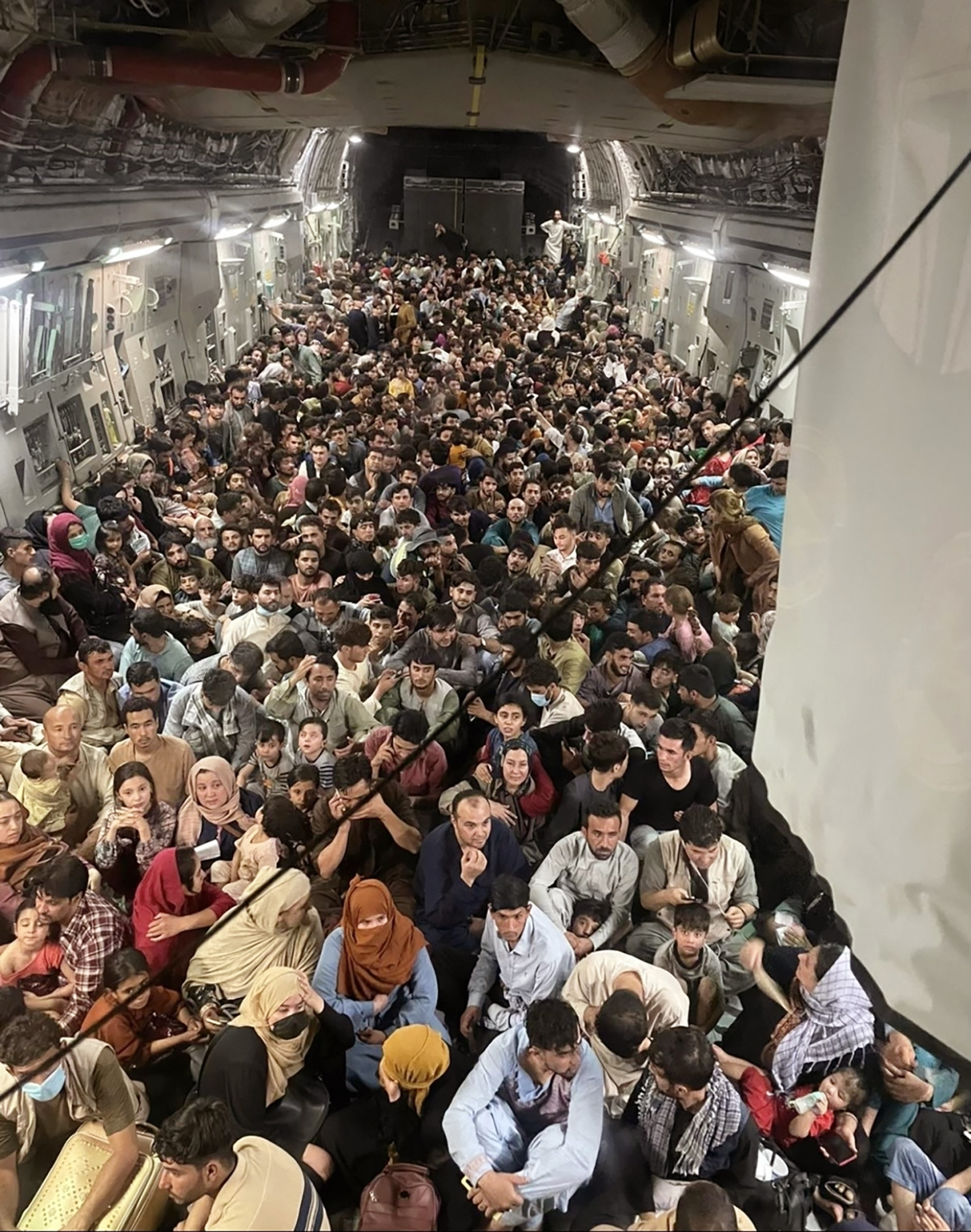 Afghan citizens pack inside a U.S. Air Force C-17 Globemaster III, as they are transported from Hamid Karzai International Airport in Afghanistan, August 15, 2021. Photo: Capt. Chris Herbert/U.S. Air Force via AP