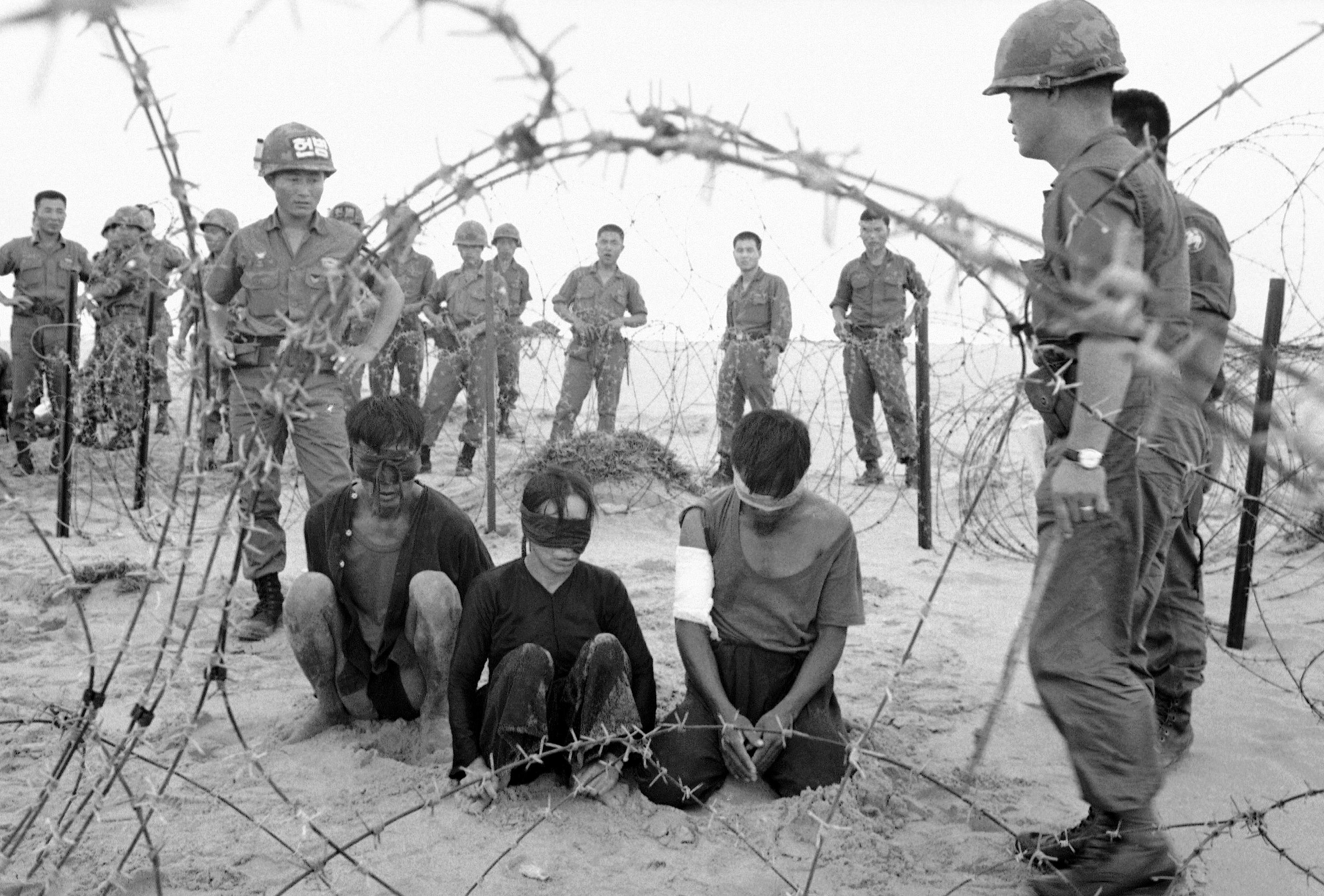 Two men and a Vietnamese woman, captured by Korean troops of the White Horse Division, are held on Nov. 30, 1966. Photo: AP Photo/Hong