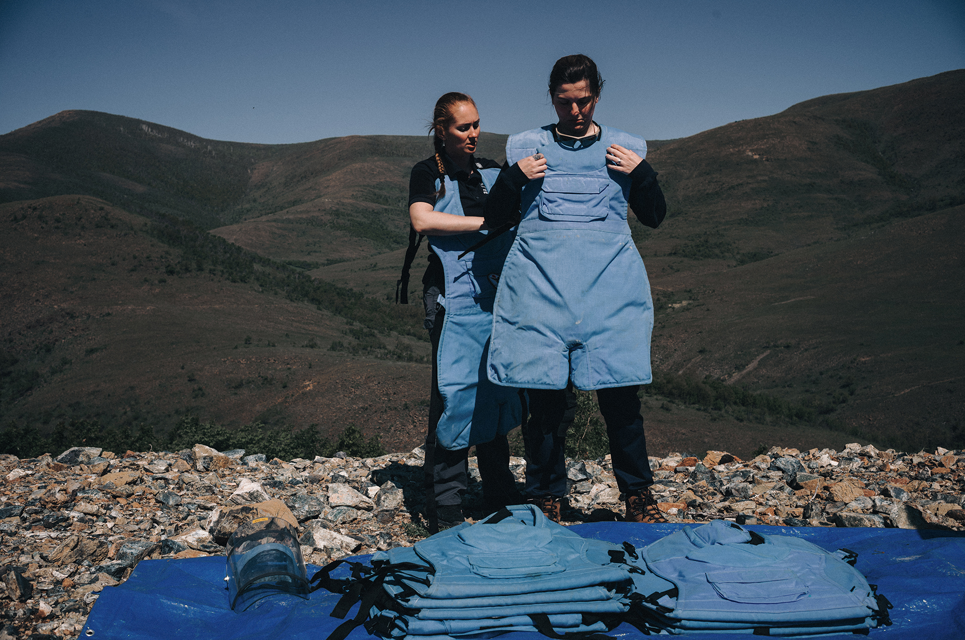 Asya Bolotova (left) helps Dasha Starikova fasten her kevlar vest which deminers wear to protect against blast injuries.