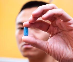 A man holding PrEP pill in hand