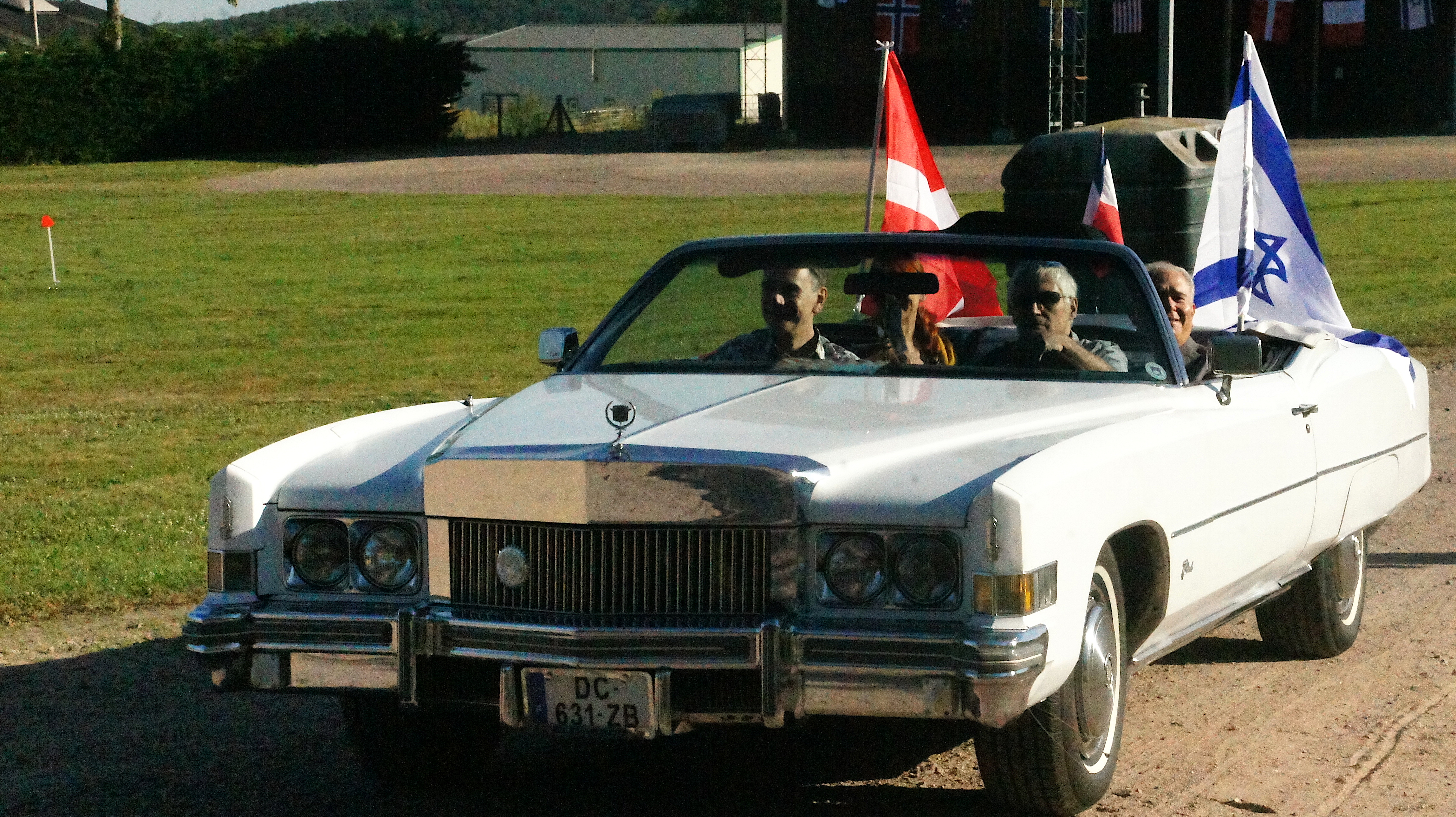 Afghan hound show – the judge's cadillac, low car with the two flags in the back, plus the french flag