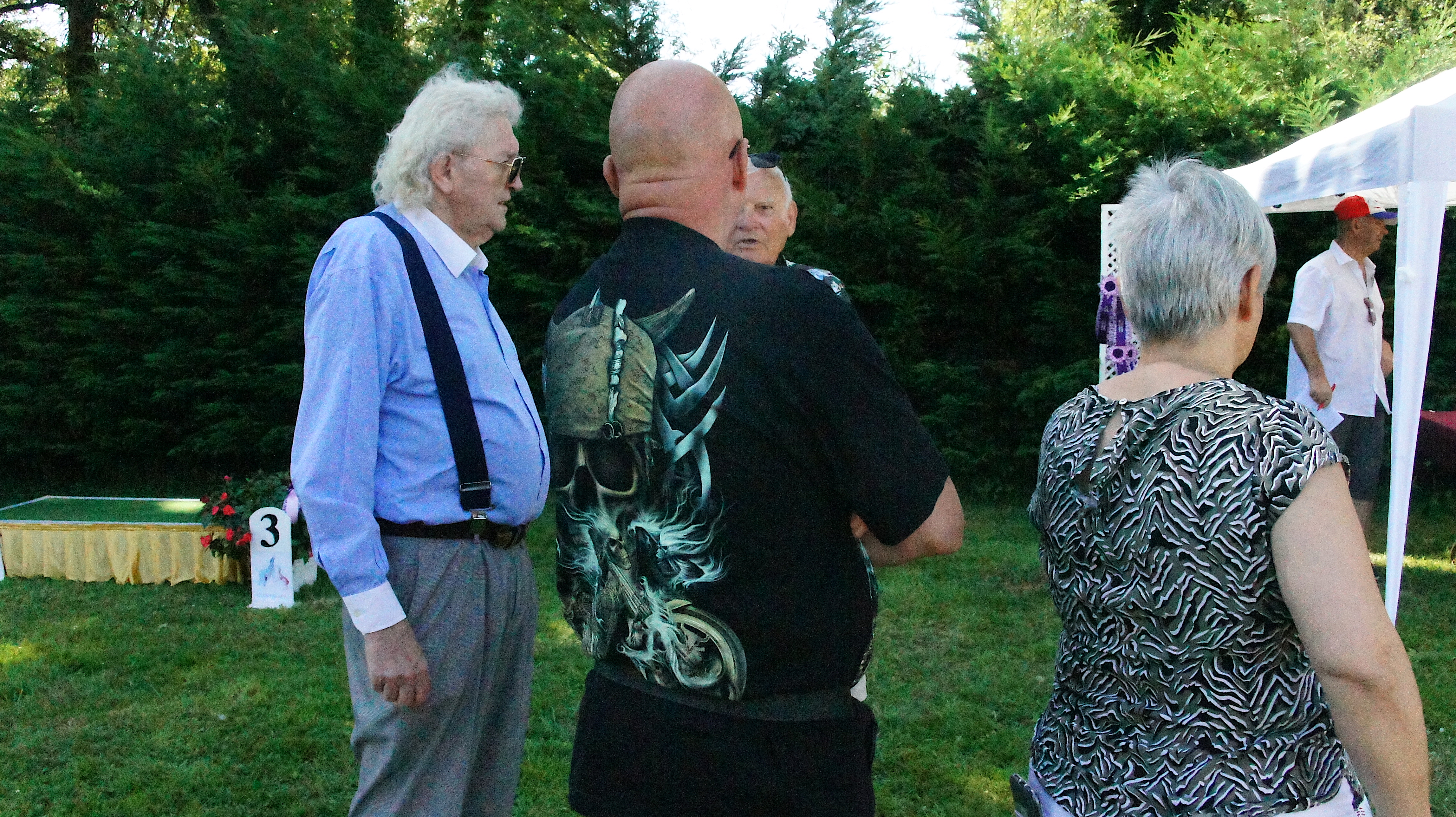 Afghan hound show – group of elderly people standing and chatting in front of a white tent