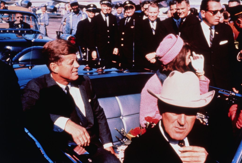 PRESIDENT JOHN F. KENNEDY AND  JACKIE KENNEDY APPEAR IN A MOTORCADE IN TEXAS. KENNEDY WAS SHOT IN THE SAME CAR.