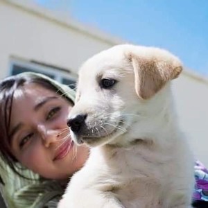 Mariam Amini, a vet from Afghanistan, holding a dog.