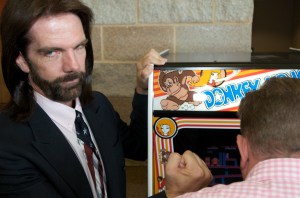 Billy Mitchell, the Video Game Player of the Century, poses while Steve Sanders, 'The Orignal King of Kong,' plays Donkey Kong at the launch party for the International Video Game Hall of Fame and Museum on August 13, 2009 in Ottumwa, Iowa.