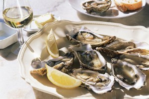 A plate of oysters with lemon and white wine