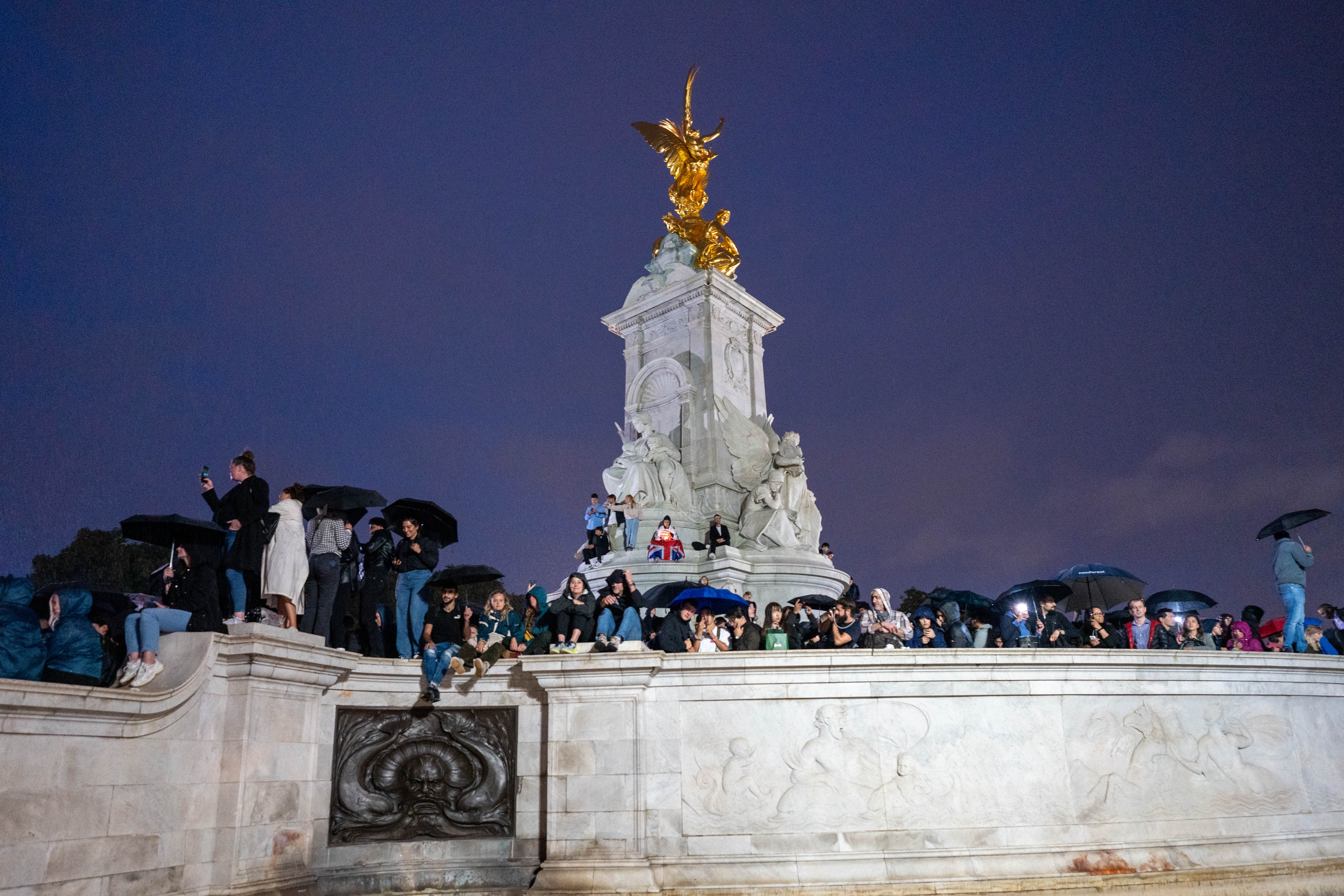 People on the Victoria memorial outside Buckingham Palace on day the Queen died