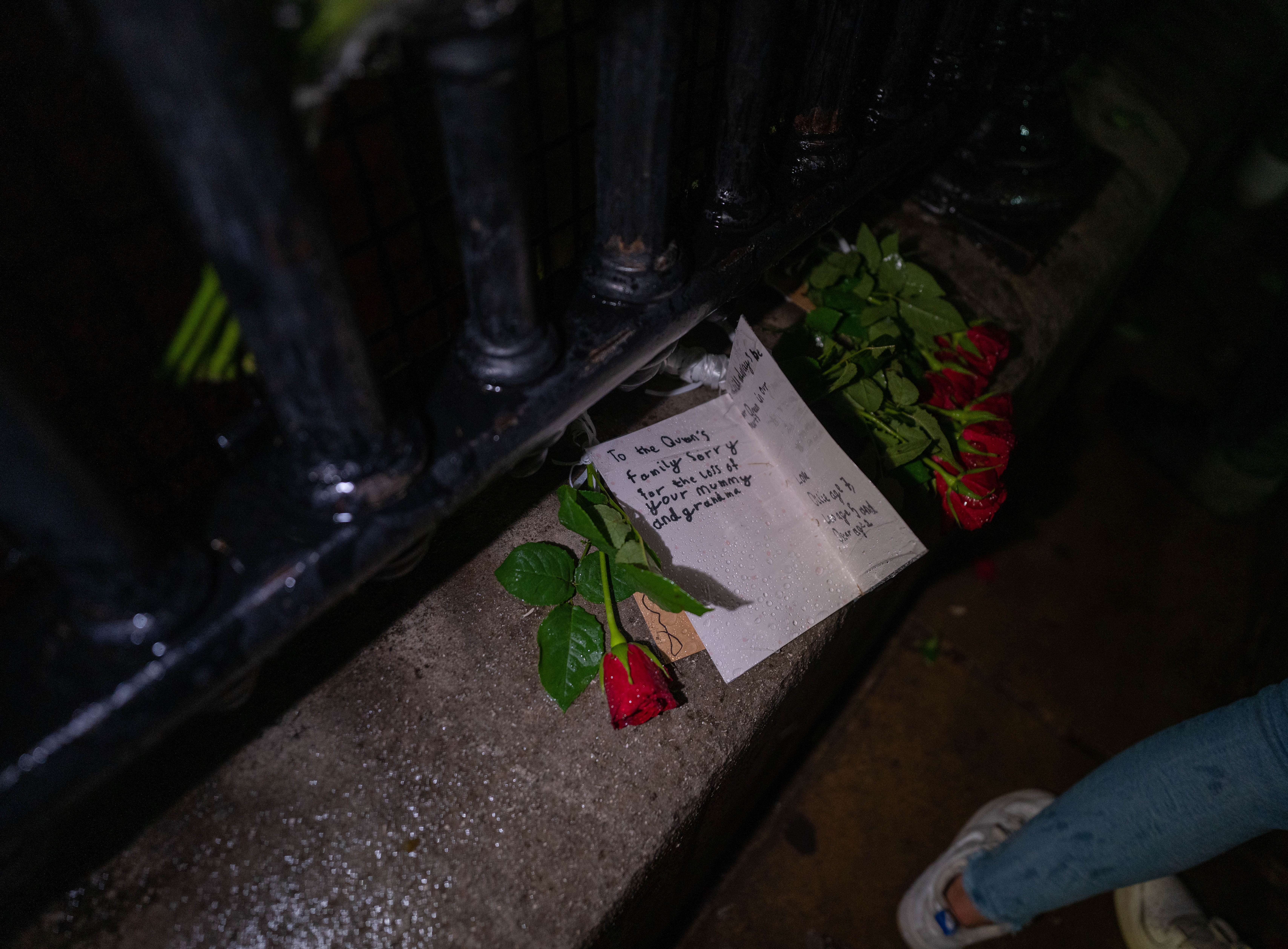 A close-up of a rose and a message outside Buckingham Palace on day the Queen died