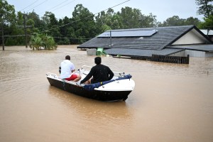 Two Queensland residents travel through flood by boat