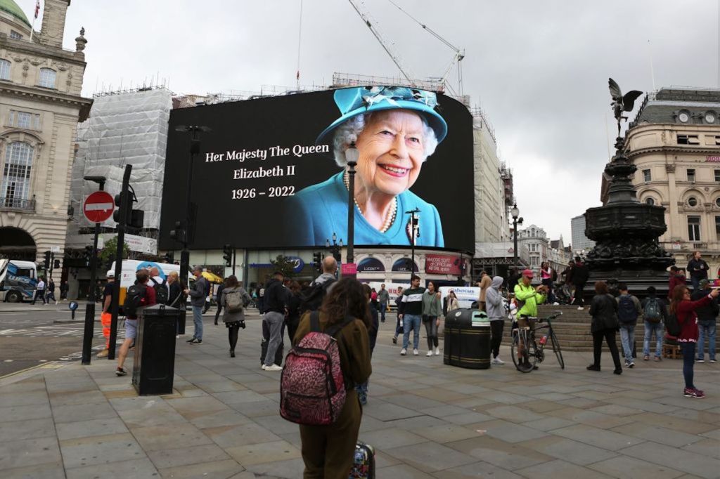 Person looks at billboard commemorating death of Queen Elizabeth II in London