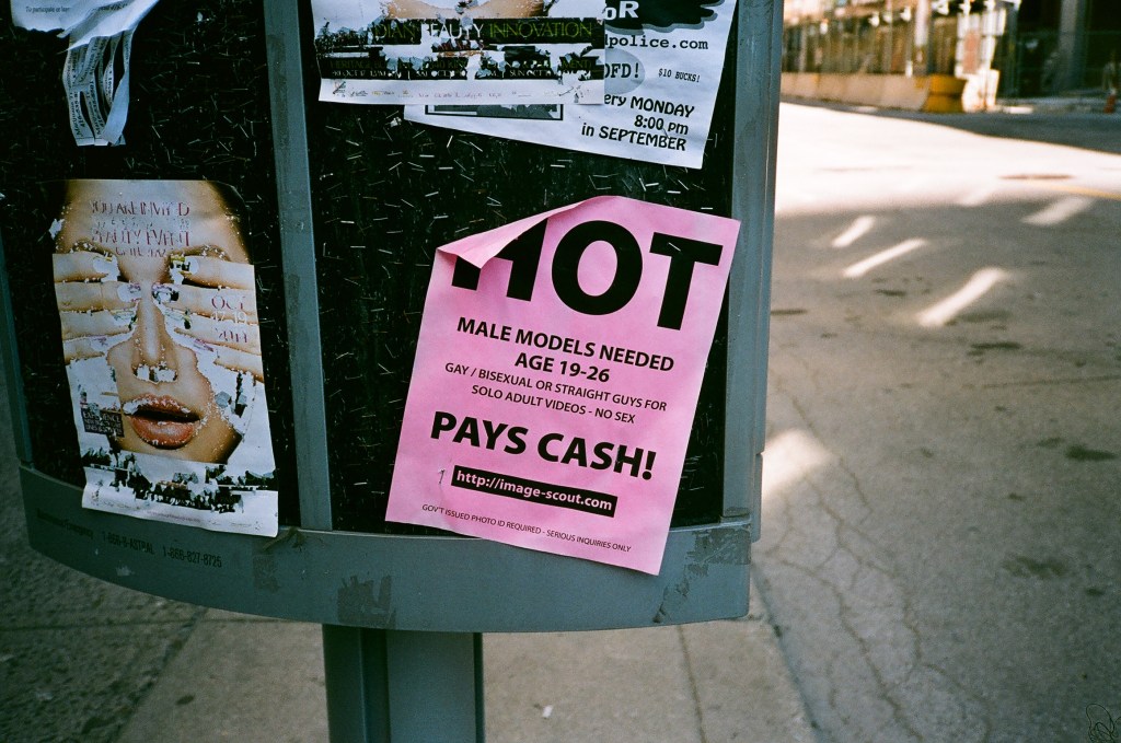 An advert for 'Hot Male Models, Pays Cash' on the street, photo by Bob Foster