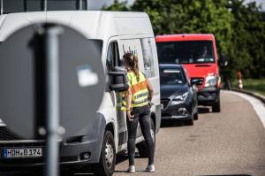 Autos stehen im Stau und eine Polizistin spricht mit einem Faher.