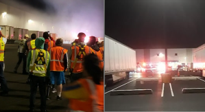 Workers wait outside a burning ALB1.