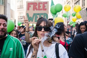 A woman smokes weed at a rally for legalization.