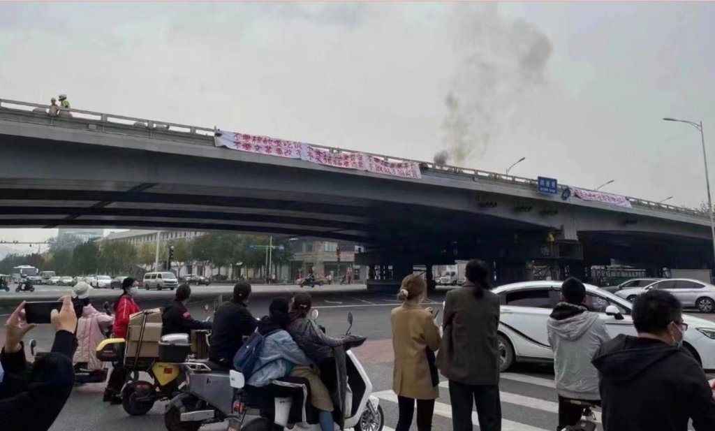 A MAN DISPLAYED TWO PROTEST BANNERS IN BEIJING IN A RARE ACT OF  PROTEST. PHOTO: TWITTER ​