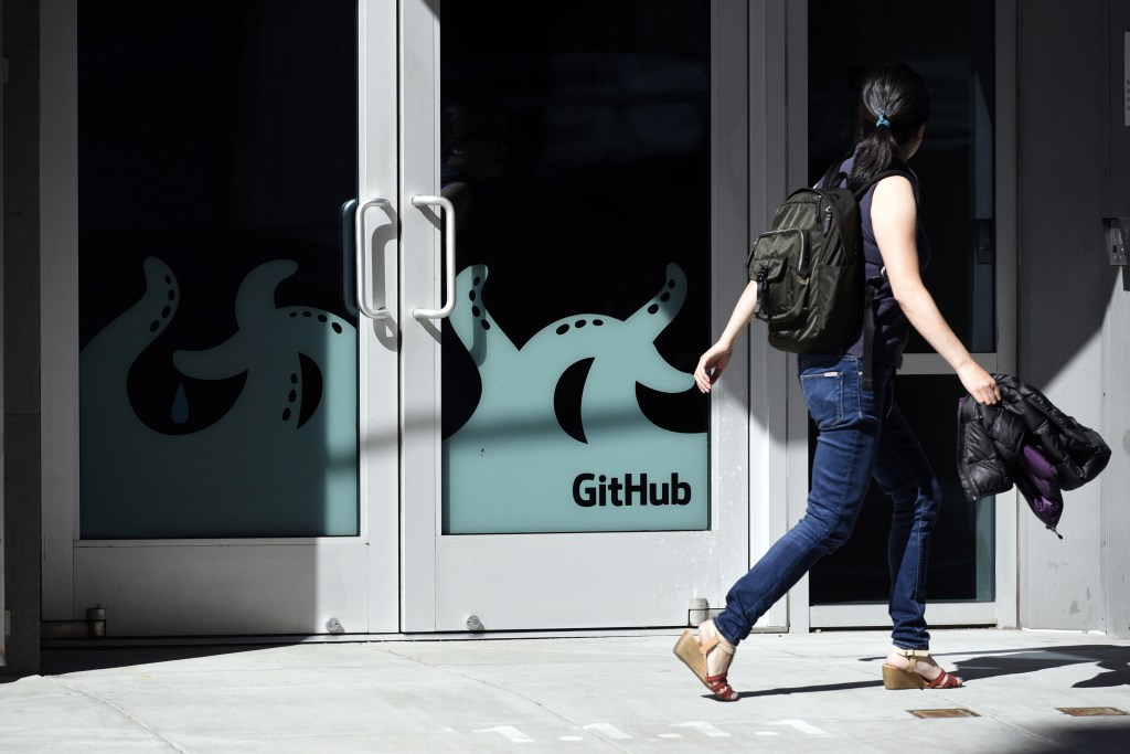 A woman walking past the door to the Github offices