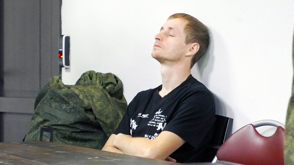 Young conscript sits with his eyes closed.