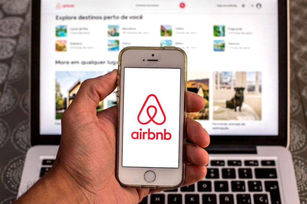 Man holding up Airbnb app on phone