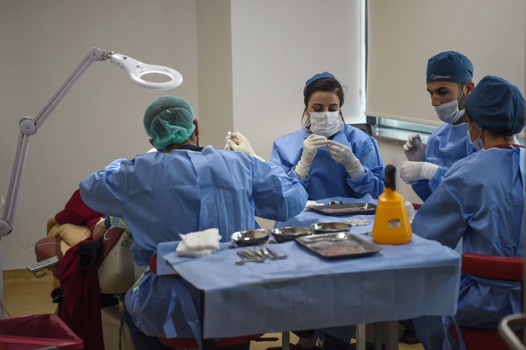 Plastic surgeons work on a hair transplant surgery on April 27, 2017 in Istanbul. With over 300 clinics specialised in hair transplant alone, Istanbul is becoming a growing hub in the industry, attracting patients from all over the world but mainly from the Middle East and the Gulf. / AFP PHOTO / OZAN KOSE (Photo credit should read OZAN KOSE/AFP via Getty Images)