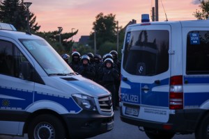 Police officers secure a demonstration through the Leipzig district of Grünau.