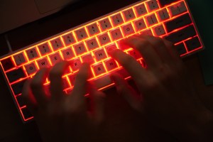 Person typing on illuminated keyboard