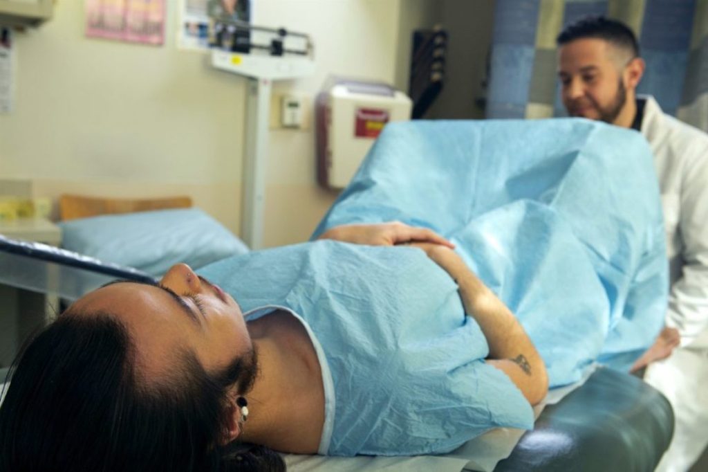 A genderqueer person receives a pelvic exam