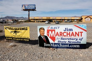 A billboard for Nevada Republican secretary of state candidate Jim Marchant is attached to a fence beside an advertisement for a gun shop on November 5, 2022 in Pahrump, Nevada