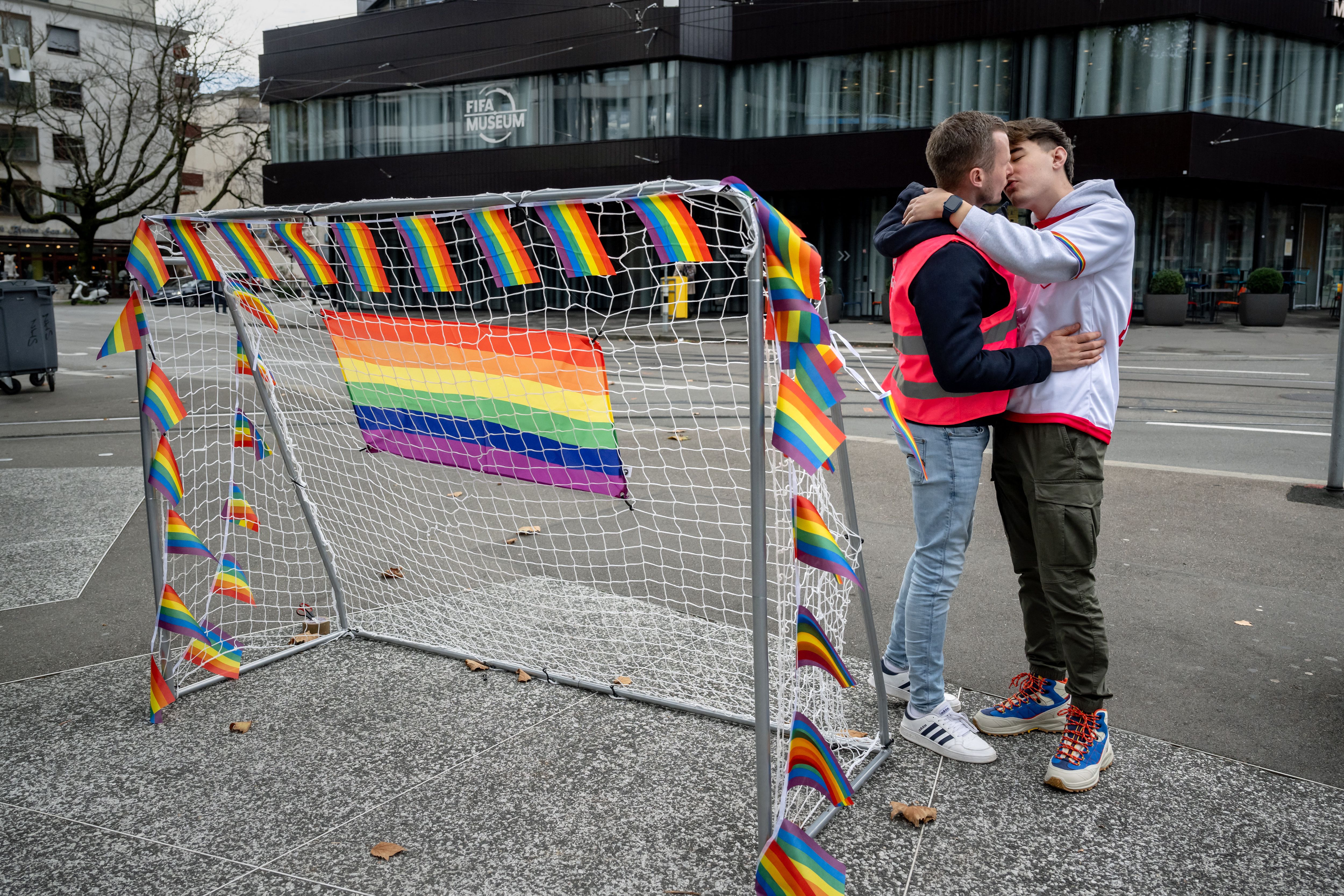 Two men kiss next to a goal during a protest against the Qatar World Cup 2022 in front of the FIFA museum in Zurich