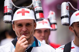 An England football fan wearing an helmet with beer cans celebrating in anticipation of the UEFA England v Italy finals game.