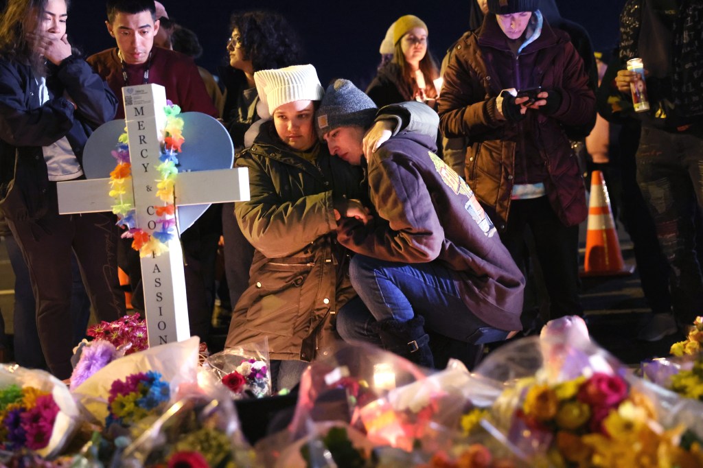 Mourners visit a makeshift memorial near the Club Q nightclub on November 21, 2022 in Colorado Springs, Colorado.