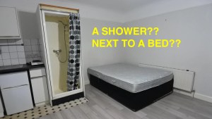 A shower next to a bed i room for rent in Willesden Green, London