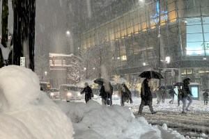 People cross the road in Niigata, Japan, amid record snowfall that has left 17 people dead.