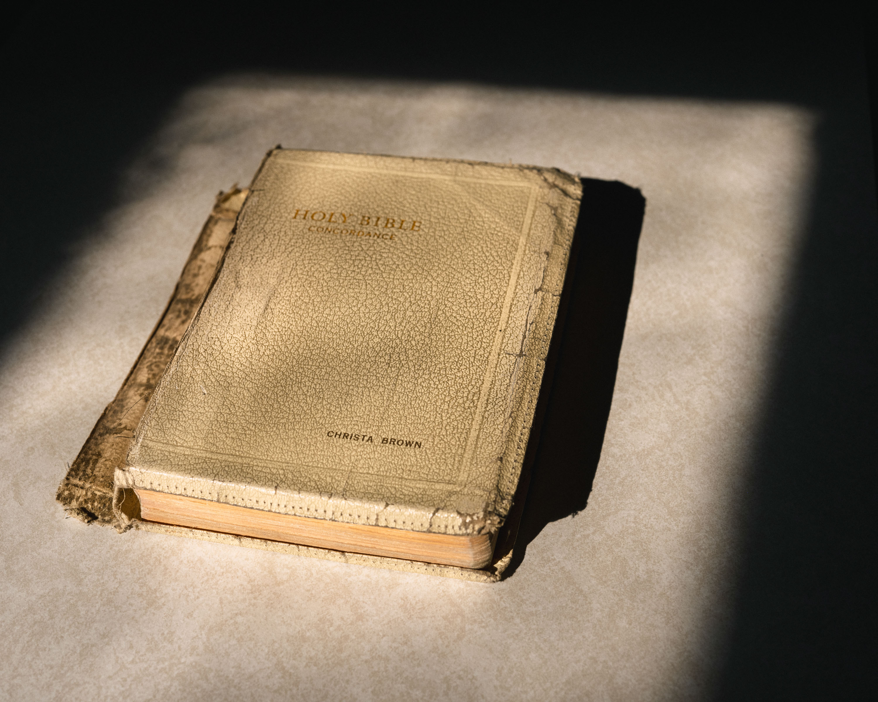 A tattered Bible with Christa's name letter-pressed into the cover.