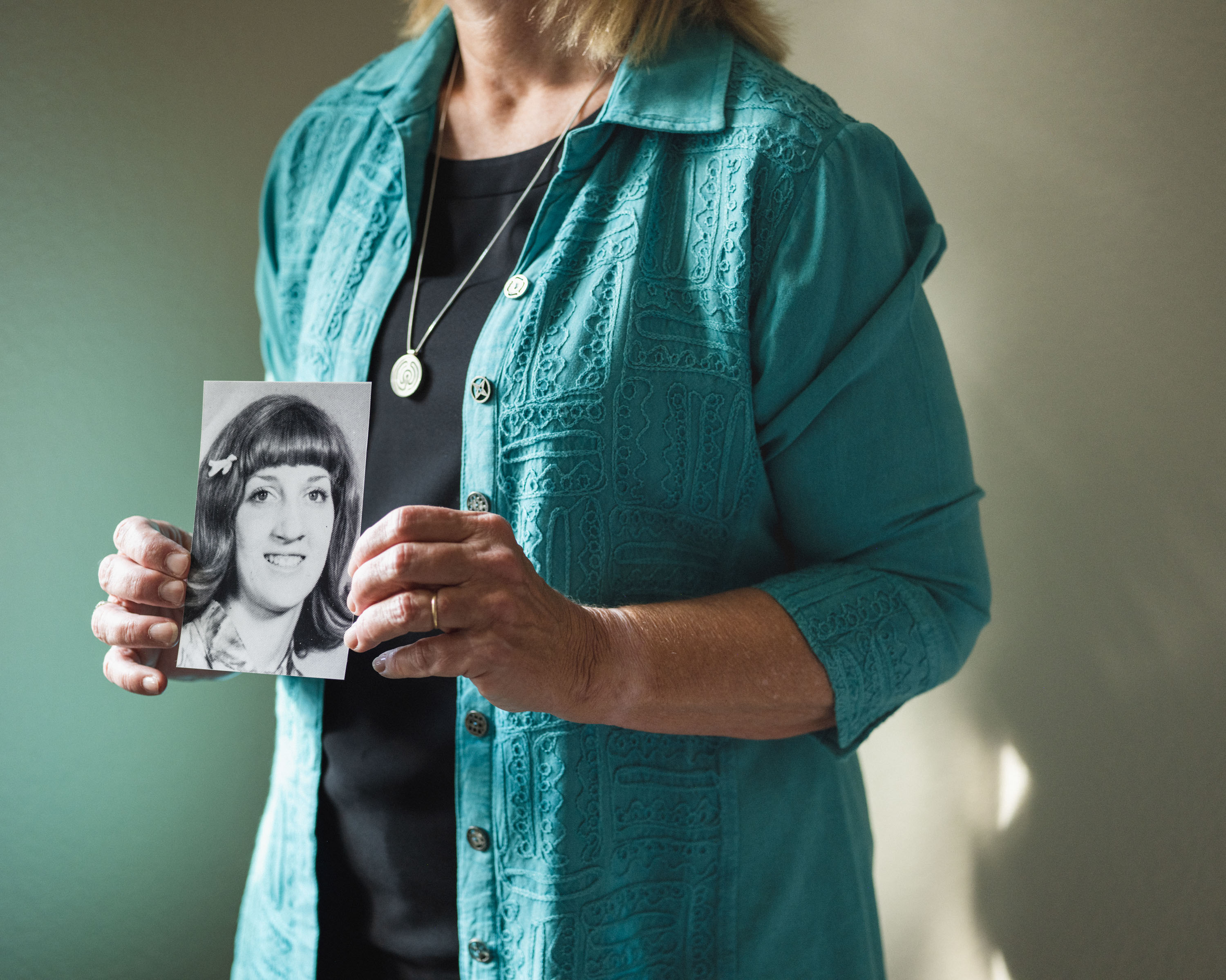 Christa Brown holding a photograph of her younger self.