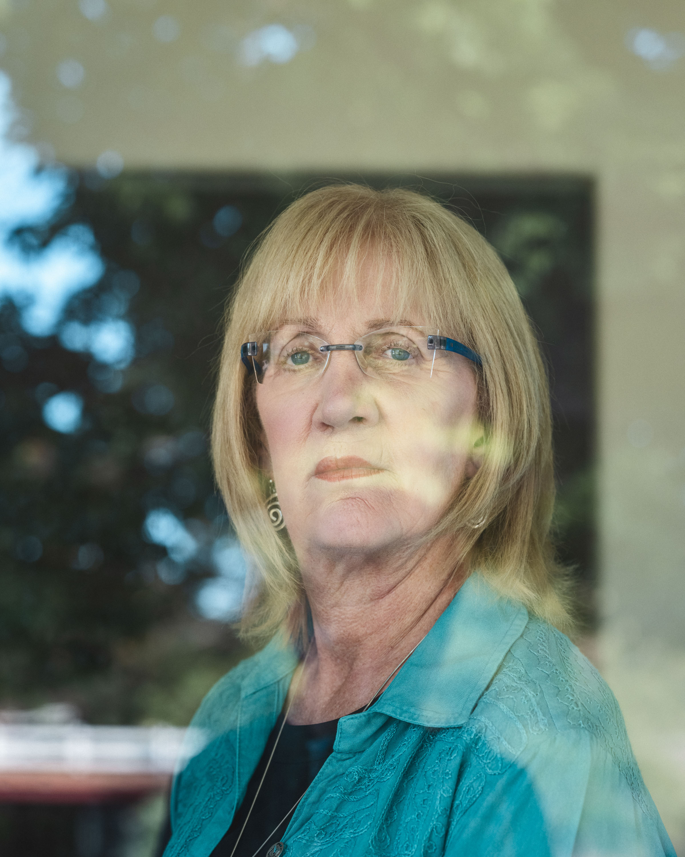 Christa Brown stands behind a glass window.