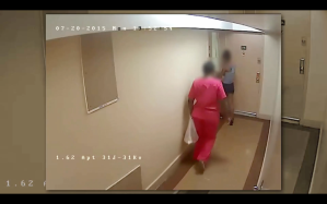 Surveillance footage of two people walking in an apartment building hallway