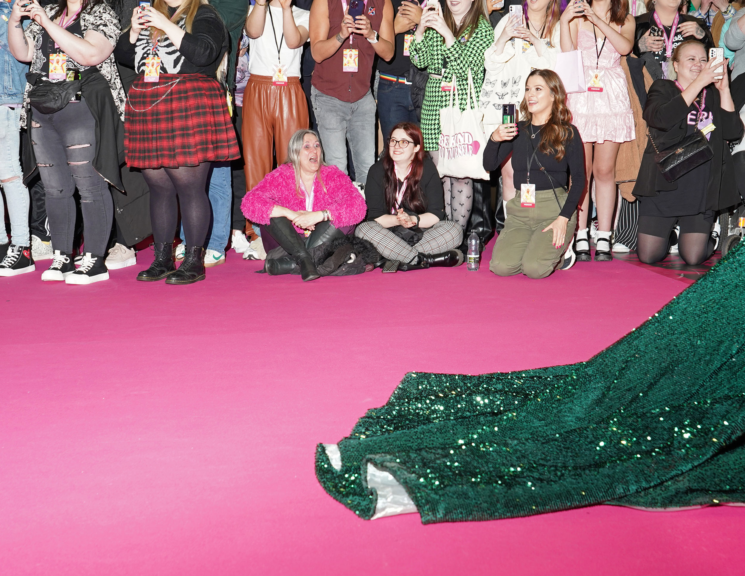 Fans watch as a drag queen walks the events’ pink carpet