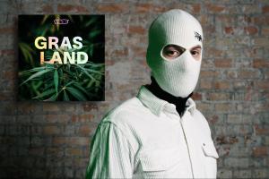 Banks trägt eine mit weißen Maske steht neben dem Logo des Podcasts Grasland.