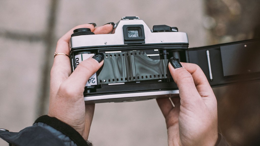 woman loading 35mm film into her analog camera