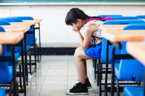 A girl sits with her head in her hands.