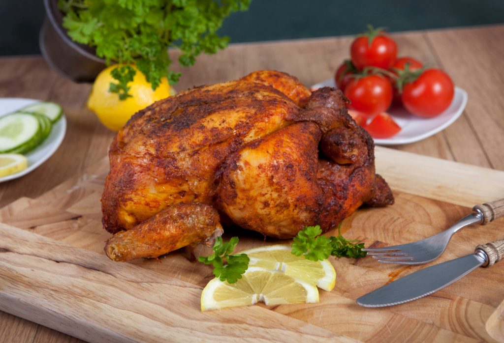 Ein Hähnchen auf einem Holzbrett. In Görlitz hat ein Mann versucht Chicken in einer Bankfiliale zu grillen.