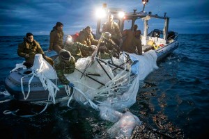 In this photo provided by the U.S. Navy, sailors assigned to Explosive Ordnance Disposal Group 2 recover a high-altitude surveillance balloon off the coast of Myrtle Beach, S.C., Feb. 5, 2023.