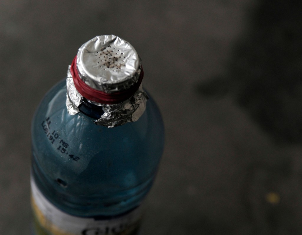 Crack pipe bottle – plastic bottle with the top covered in tin foil with a few holes in it, fastened by a rubber band.