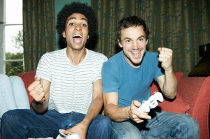 Two male friends playing video games together