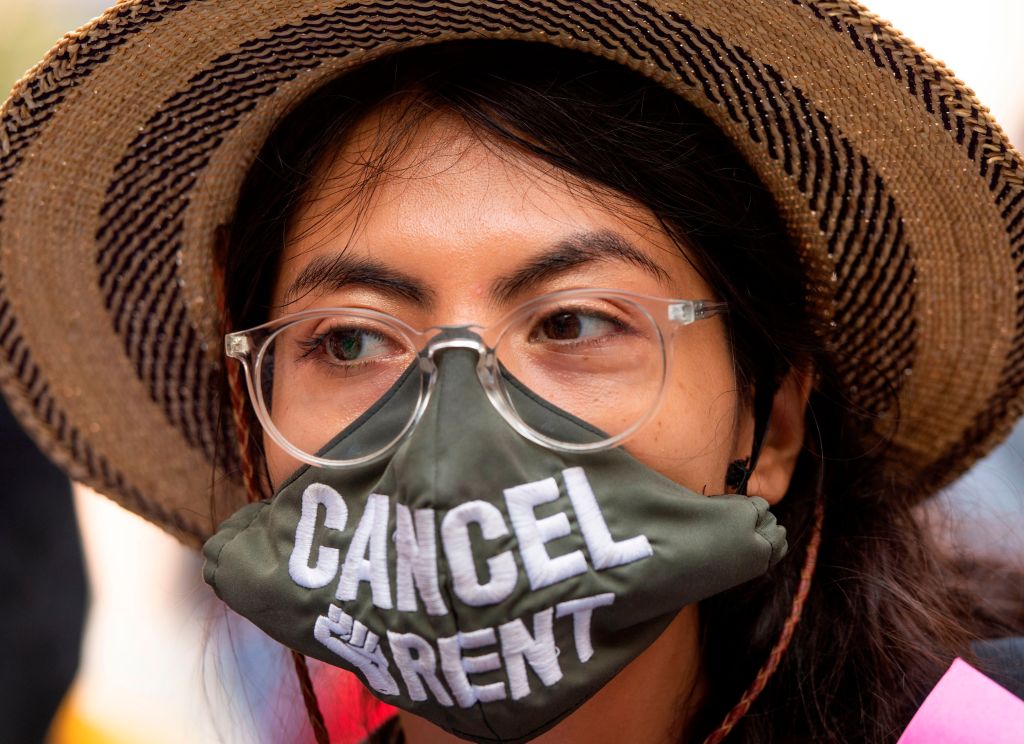 A protester wearing a 'Cancel Rent' mask